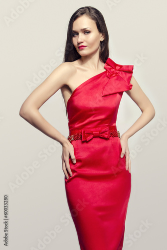 Brunette woman wearing an elegant red dress posing fashion