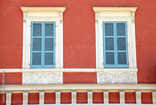 old french blue shutter windows in red house, Nice, France.