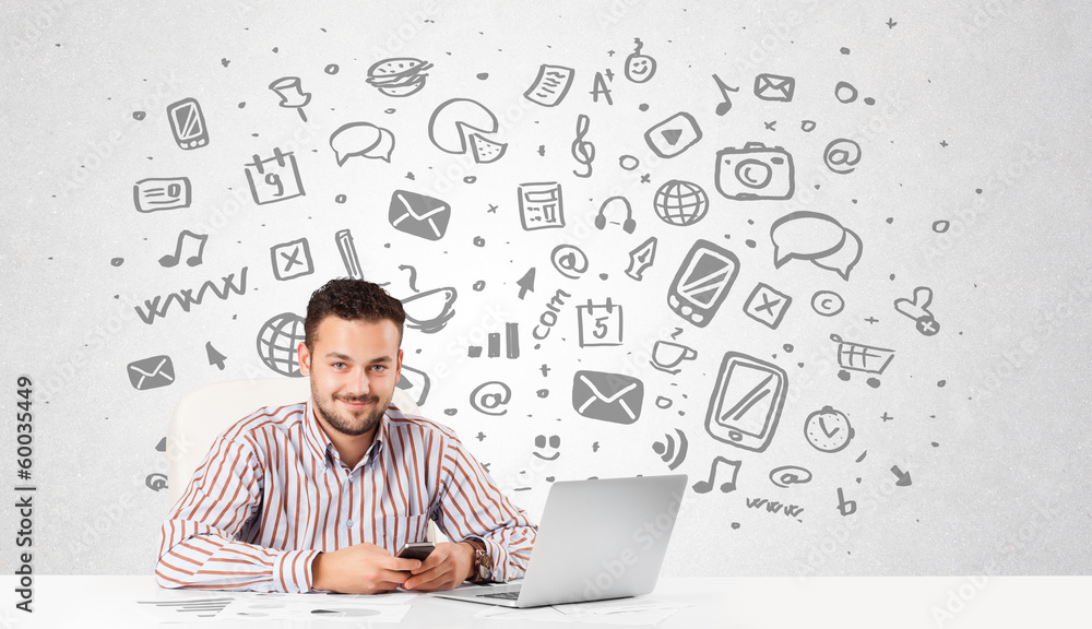 Young businessman with all kind of hand-drawn media icons in bac Young businessman with all kind of hand-drawn media icons in bac