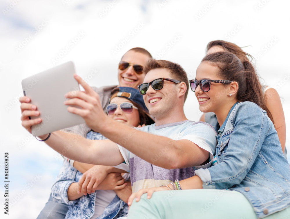 Fototapeta premium group of smiling teenagers looking at tablet pc