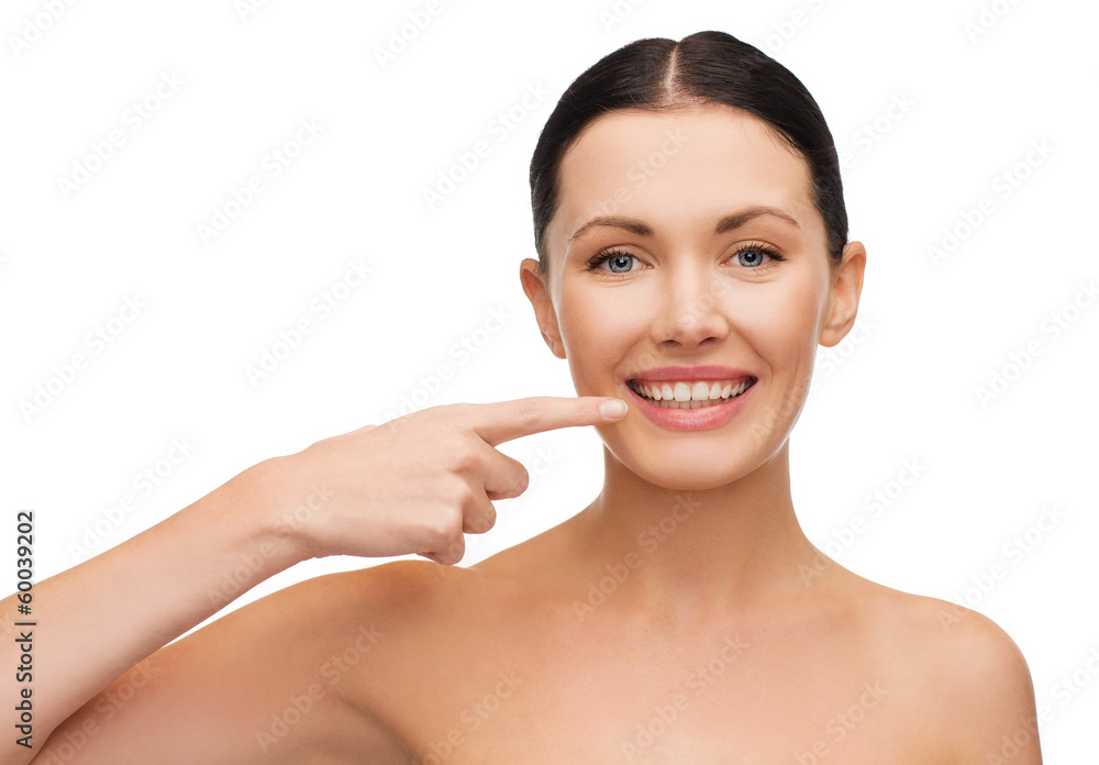 young calm woman pointing to her mouth young calm woman pointing to her mouth
