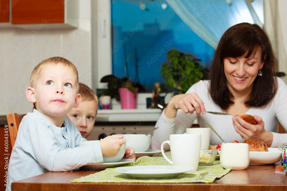 Family eating corn flakes and bread breakfast meal at the table Family eating corn flakes and bread breakfast meal at the table