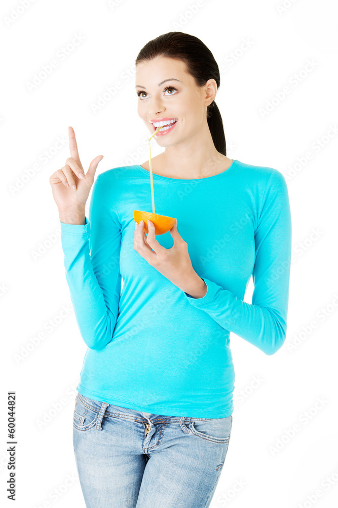 Beautiful young woman drinking juice from orange. Beautiful young woman drinking juice from orange.