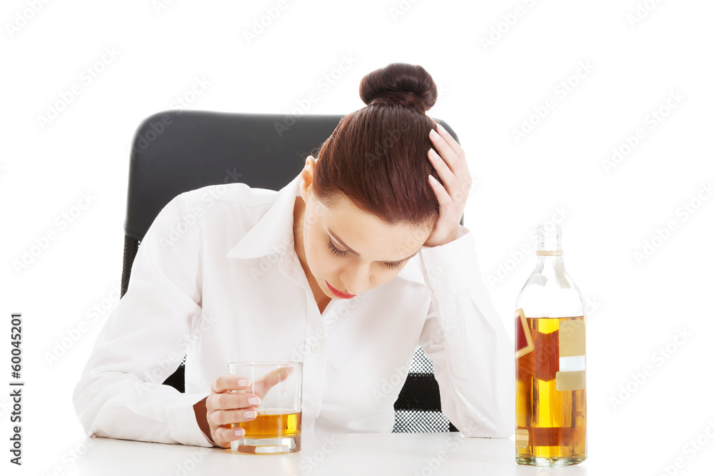 Young beautiful business woman with glass of whisky or rum. Young beautiful business woman with glass of whisky or rum.
