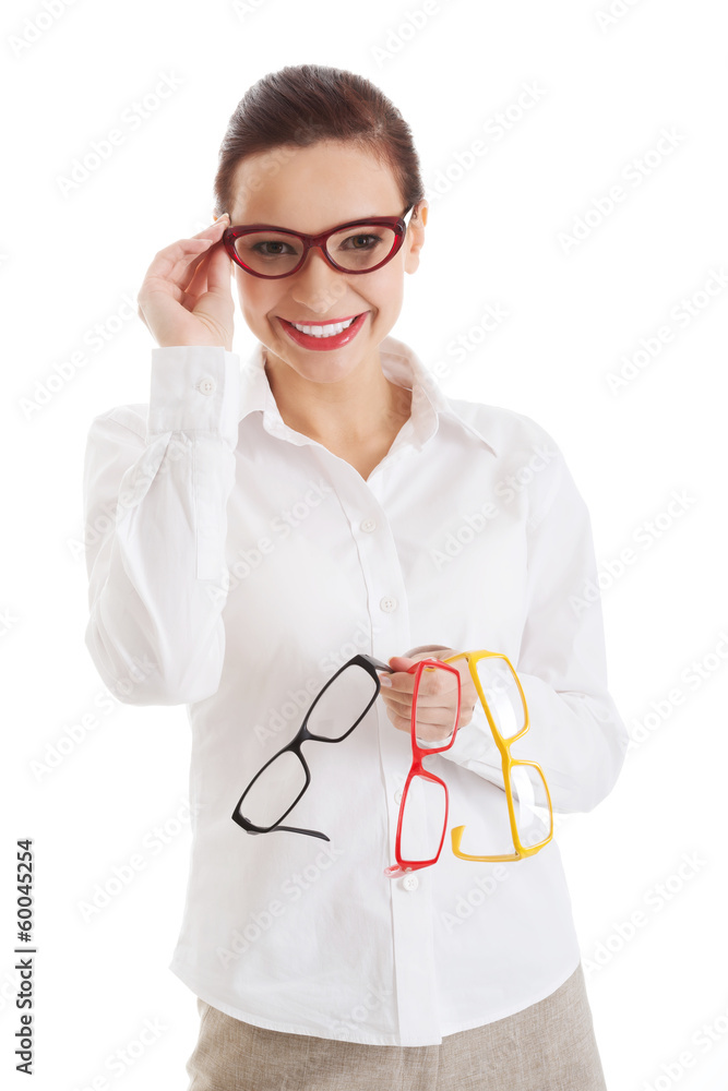 Beautiful woman in eyeglasses holding three different pair of ey Beautiful woman in eyeglasses holding three different pair of ey