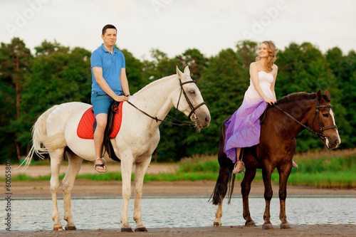 man and woman with a horses at the sea. Romantic love.
