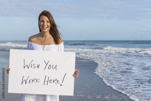 Valokuva Woman on Beach Holding Wish You Were Here Card