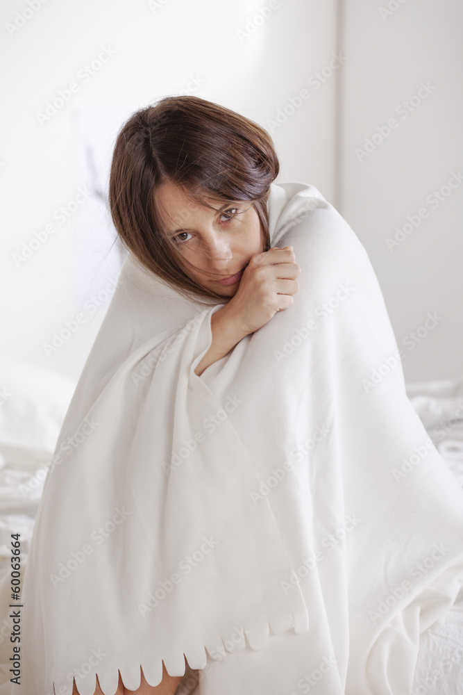 Young woman resting with white blanket on bed. Young woman resting with white blanket on bed.