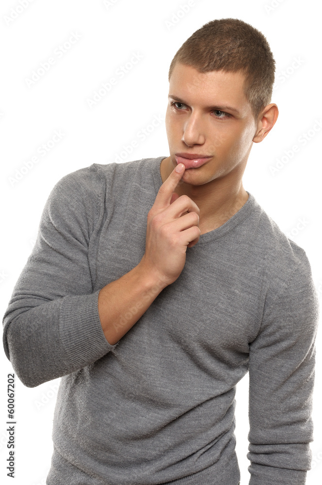 Handsome young man posing and with the index finger touching the Handsome young man posing and with the index finger touching the