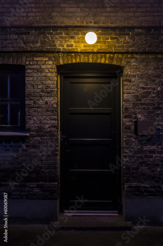 Black door in dark alley at night