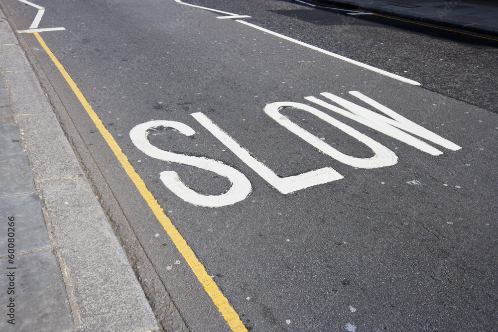 Fototapeta premium Close-Up of road marking saying Slow in London, UK