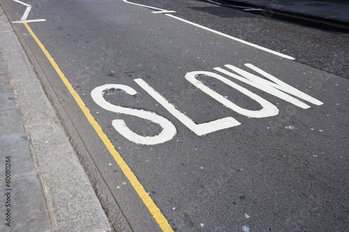 Close-Up of road marking saying Slow in London, UK