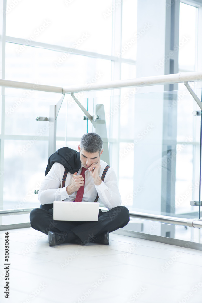 Businessman sitting on floor using laptop Businessman sitting on floor using laptop