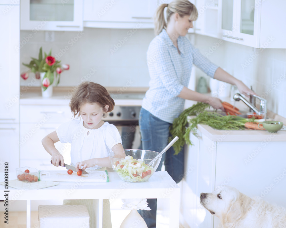 Mother and Daughter (8-9) preparing healthy meal in kitchen