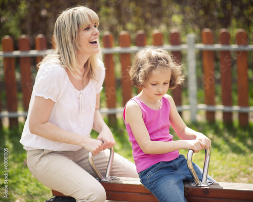 Mother and daughter ride seesaw together © moodboard
