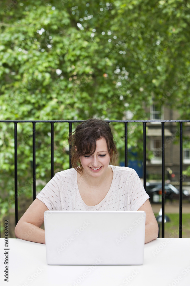 Happy young businesswoman using laptop at desk Happy young businesswoman using laptop at desk