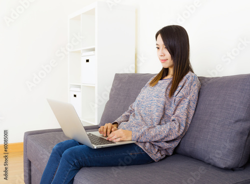 Woman using laptop at home © leungchopan