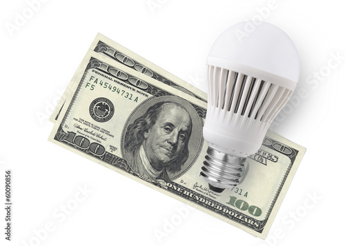 LED bulb over dollar bills isolated on white background