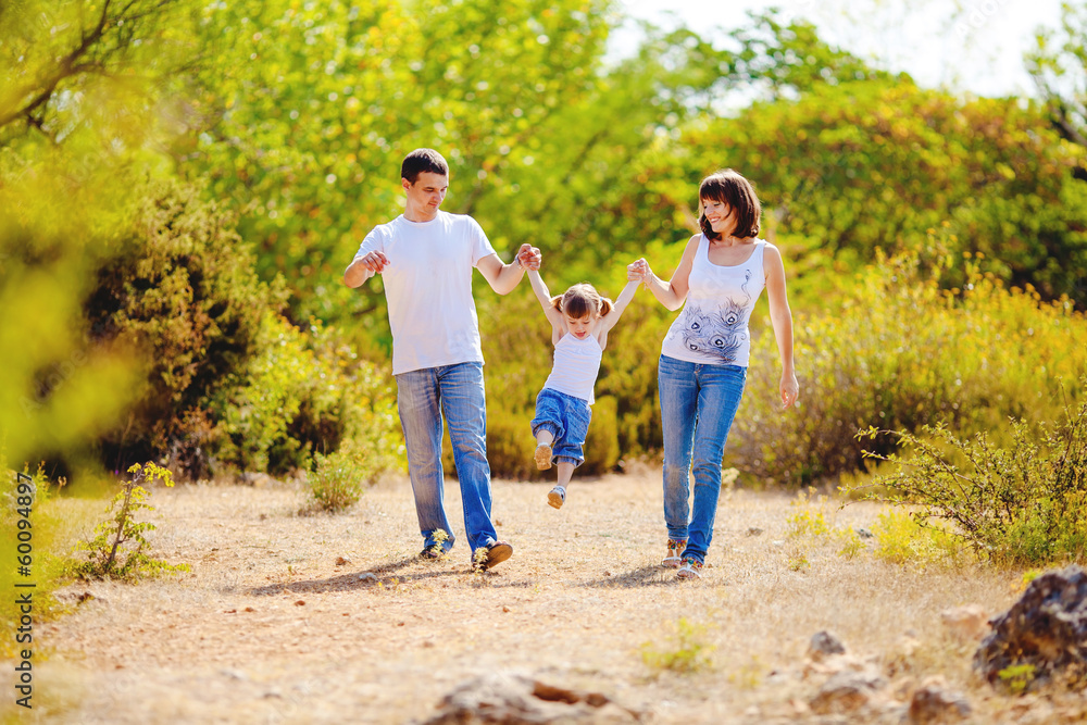 Happy young family with child resting outdoors in summer park Happy young family with child resting outdoors in summer park