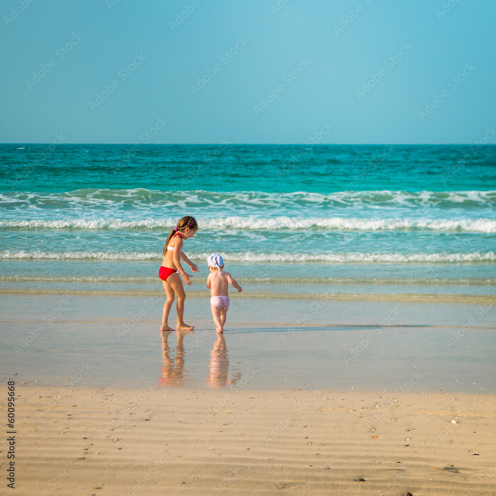 little sisters walking along the beach little sisters walking along the beach