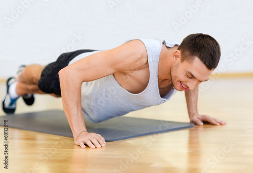 smiling man doing push-ups in the gym