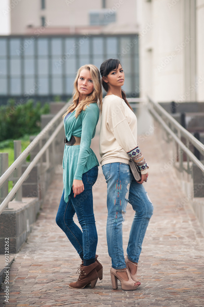 Two girls portrait outdoors with green park as background. Full