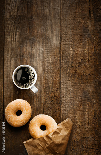Sugared doughnuts and coffee on rustic wood Fototapeta