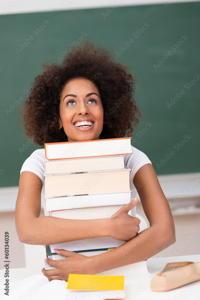studentin umarmt einen stapel bücher studentin umarmt einen stapel bücher