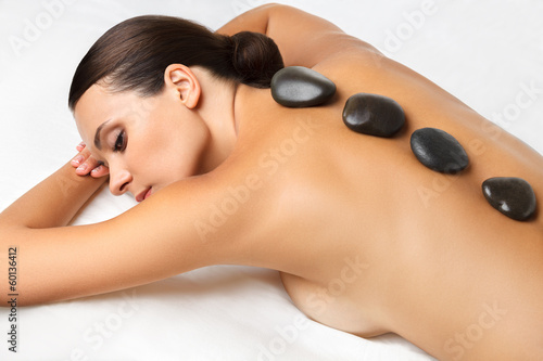 Stone Massage. Beautiful Woman Getting Spa Hot Stones Massage 