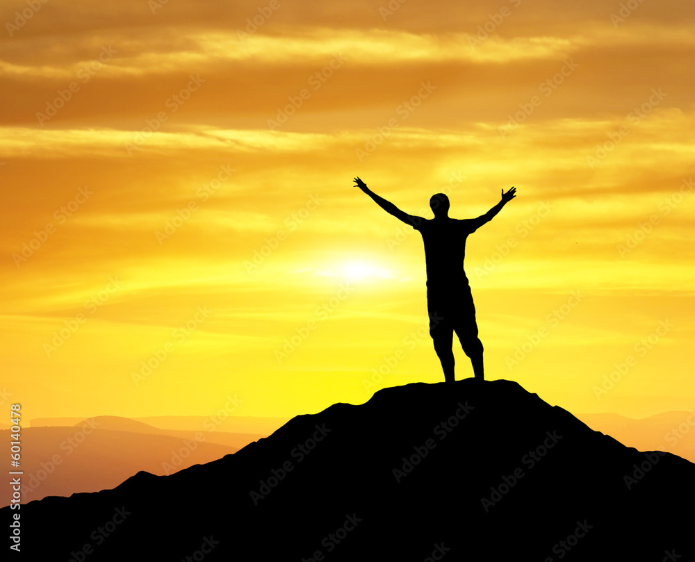 Silhouette of a winner on the mountain top Silhouette of a winner on the mountain top