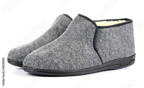 Pair of men's grey slippers on white background.