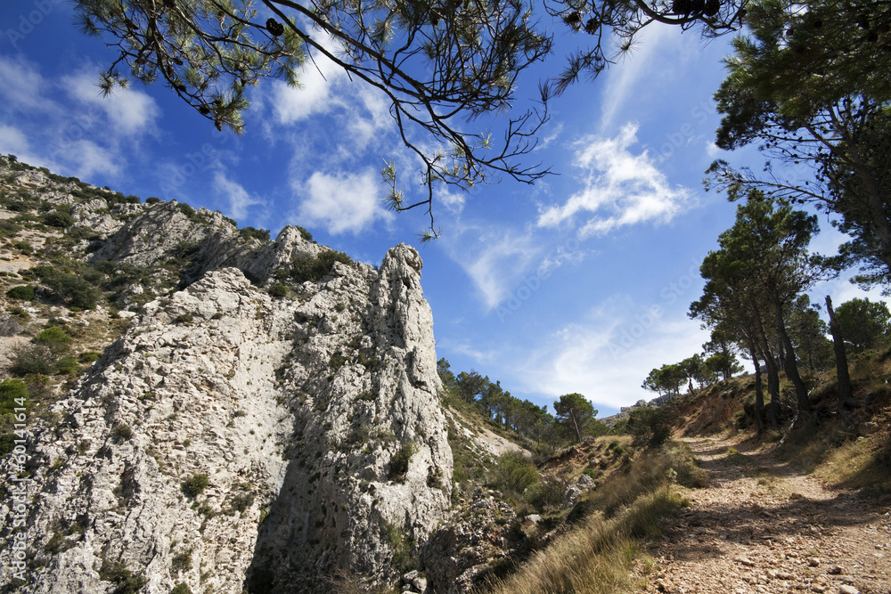 Fototapeta premium Country road in the hills with mountain rock in Alicante, Spain