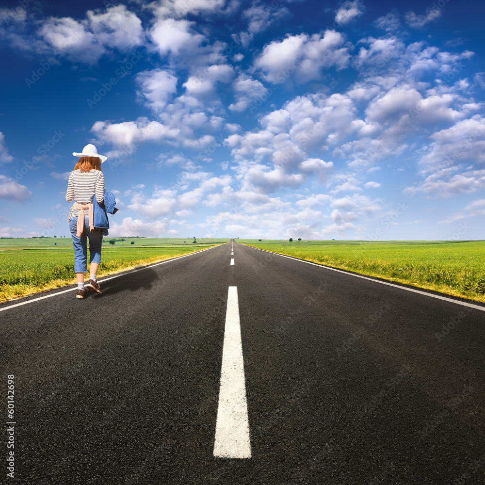 Lonely girl walking on empty road