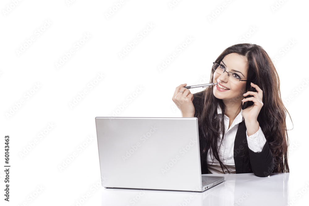 smiling business woman talking on her phone next to a laptop smiling business woman talking on her phone next to a laptop