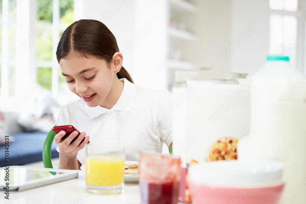 Schoolgirl With Digital Tablet And Mobile At Breakfast Schoolgirl With Digital Tablet And Mobile At Breakfast