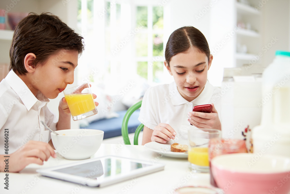 Schoolchildren With Digital Tablet And Mobile At Breakfast Schoolchildren With Digital Tablet And Mobile At Breakfast