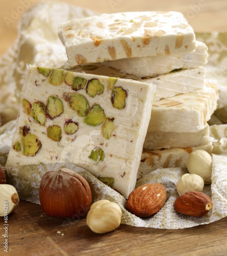 white nougat with different nuts on a wooden table