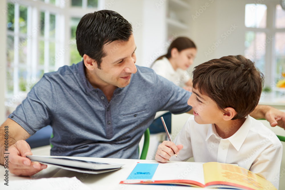 Father Helping Son With Homework Using Digital Tablet Father Helping Son With Homework Using Digital Tablet