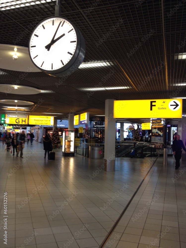 Clock and gate signs in a busy airport