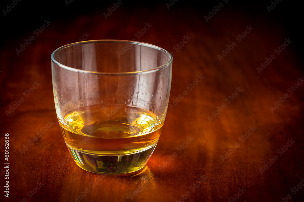 Glass of scotch or rum on a vintage wooden table