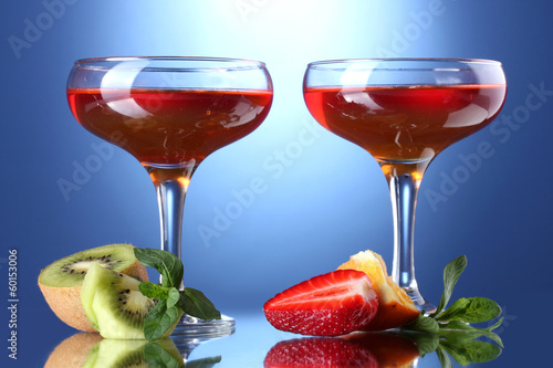 fruit jelly in glasses and fruits on blue background