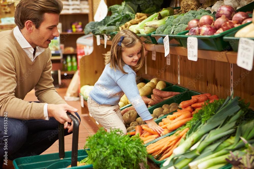 Father And Daughter Choosing Fresh Vegetables In Farm Shop Father And Daughter Choosing Fresh Vegetables In Farm Shop