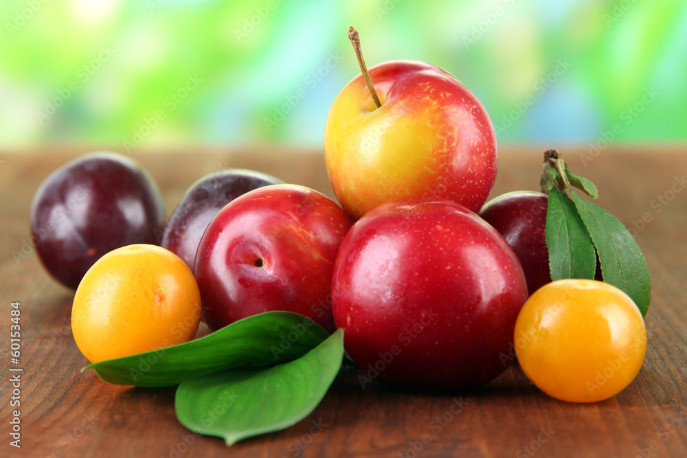 Ripe plums on wooden table on natural background Ripe plums on wooden table on natural background