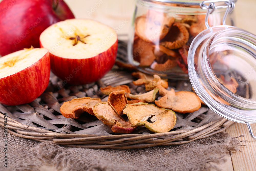 Dried apples in glass jar, on color wooden background Dried apples in glass jar, on color wooden background