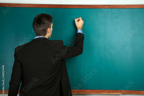 Young teacher near chalkboa...
