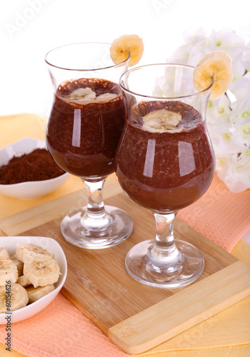 Cocktails with banana and chocolate on table on white