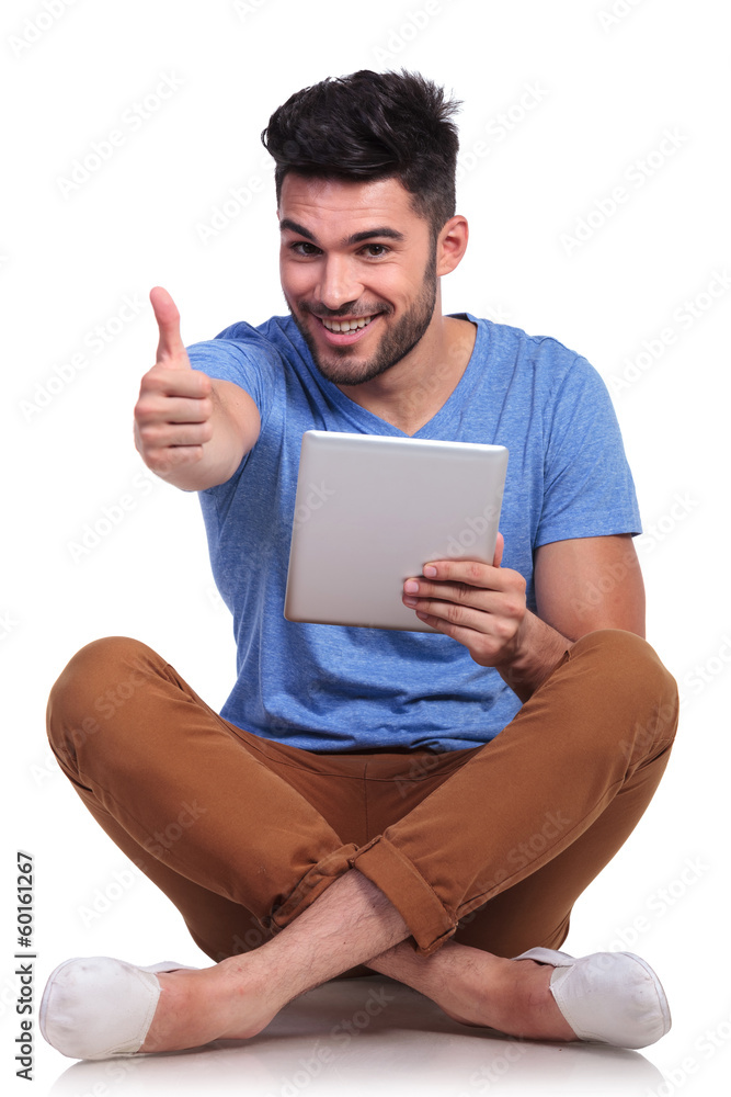 seated happy  man reading good news on his tablet