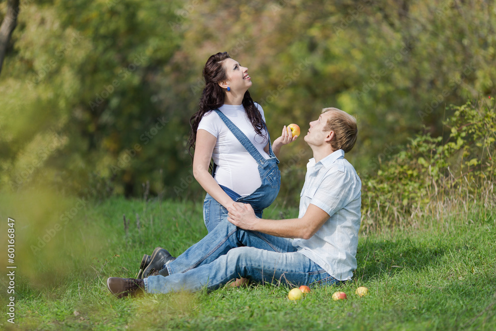 Fototapeta premium Young man with his pregnant wife on open air