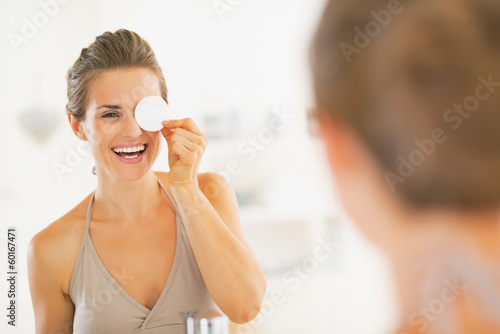 Young woman using with cotton pad in bathroom