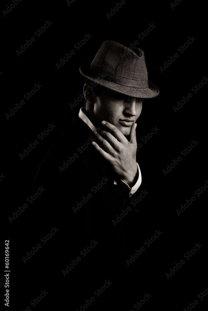 low key portrait of young gangster with hat in the darkness. low key portrait of young gangster with hat in the darkness.